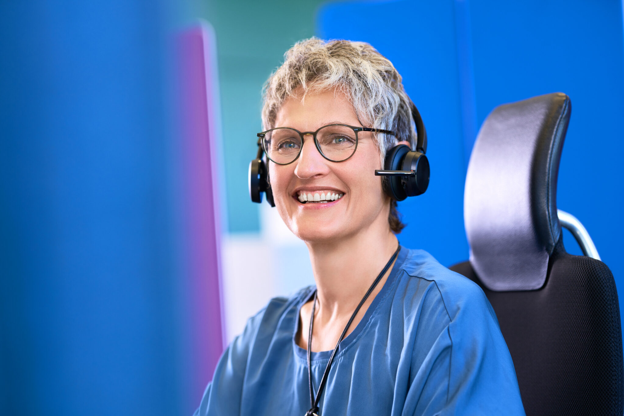 Mitarbeiterin von Compass Pflegeberatung mit Headset am Computer