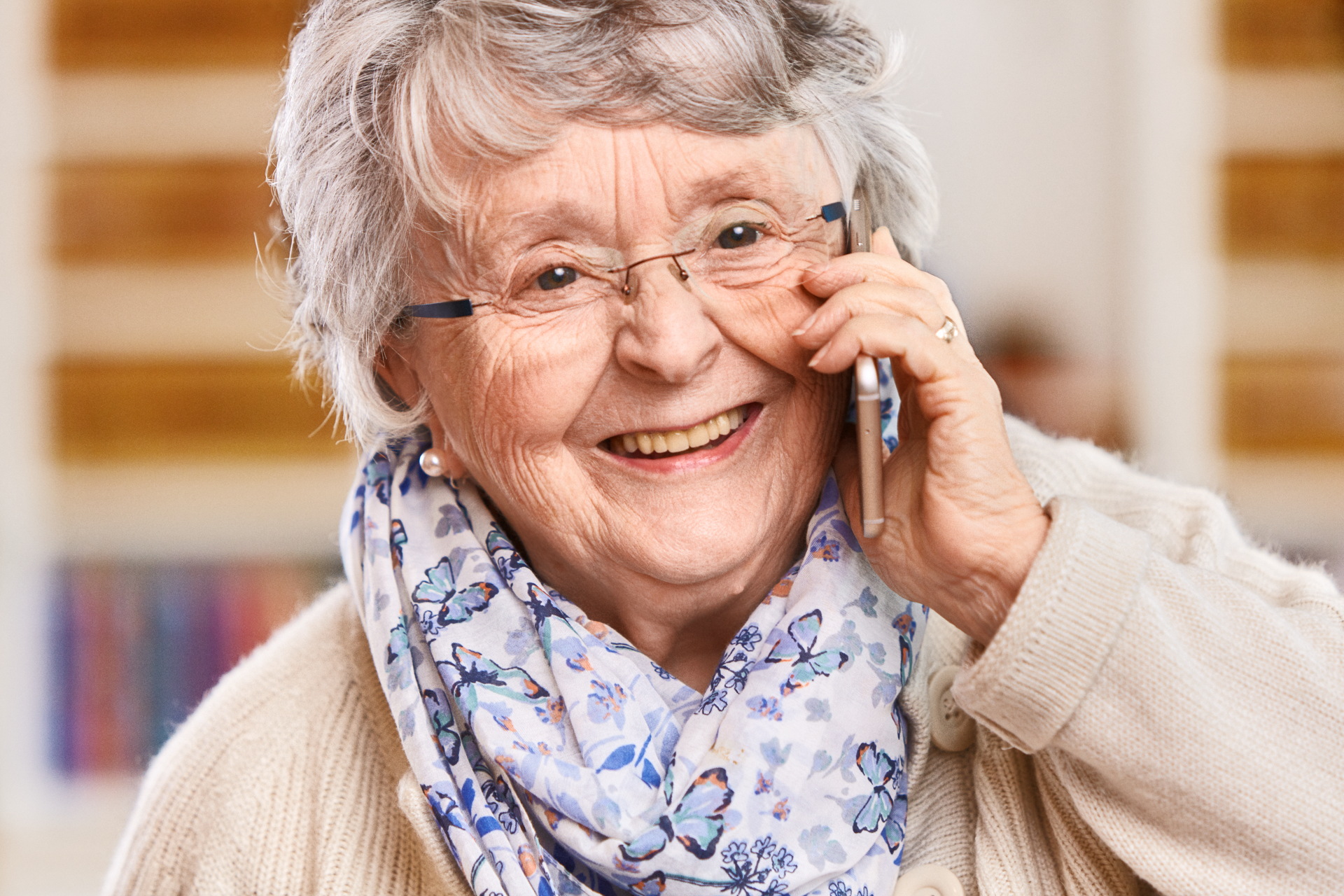 Lächelnde Seniorin telefoniert mit einem Smartphone
