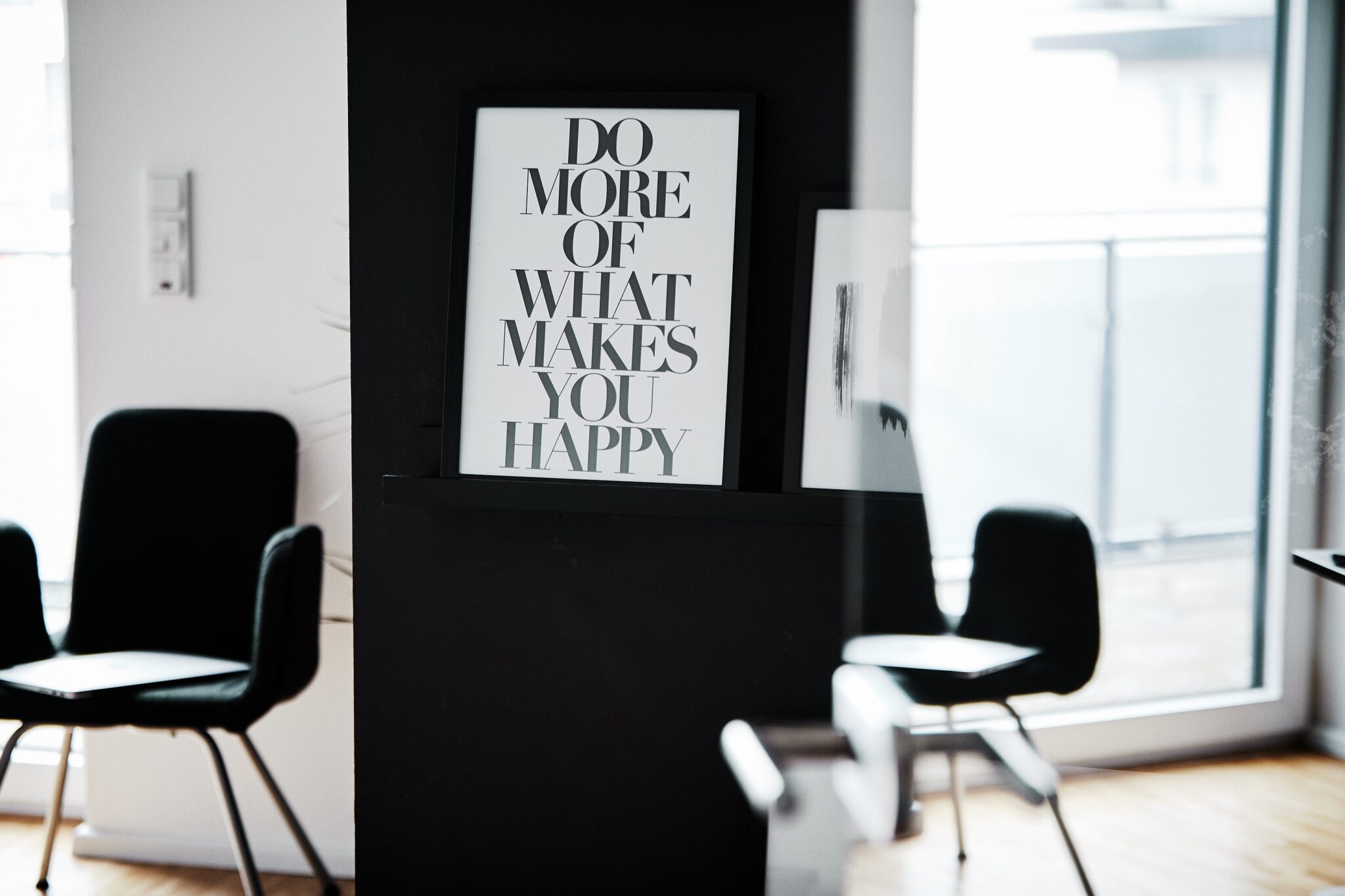 Büro von Denkagil mit schwarzen Stühlen und gerahmtem Motivationsposter