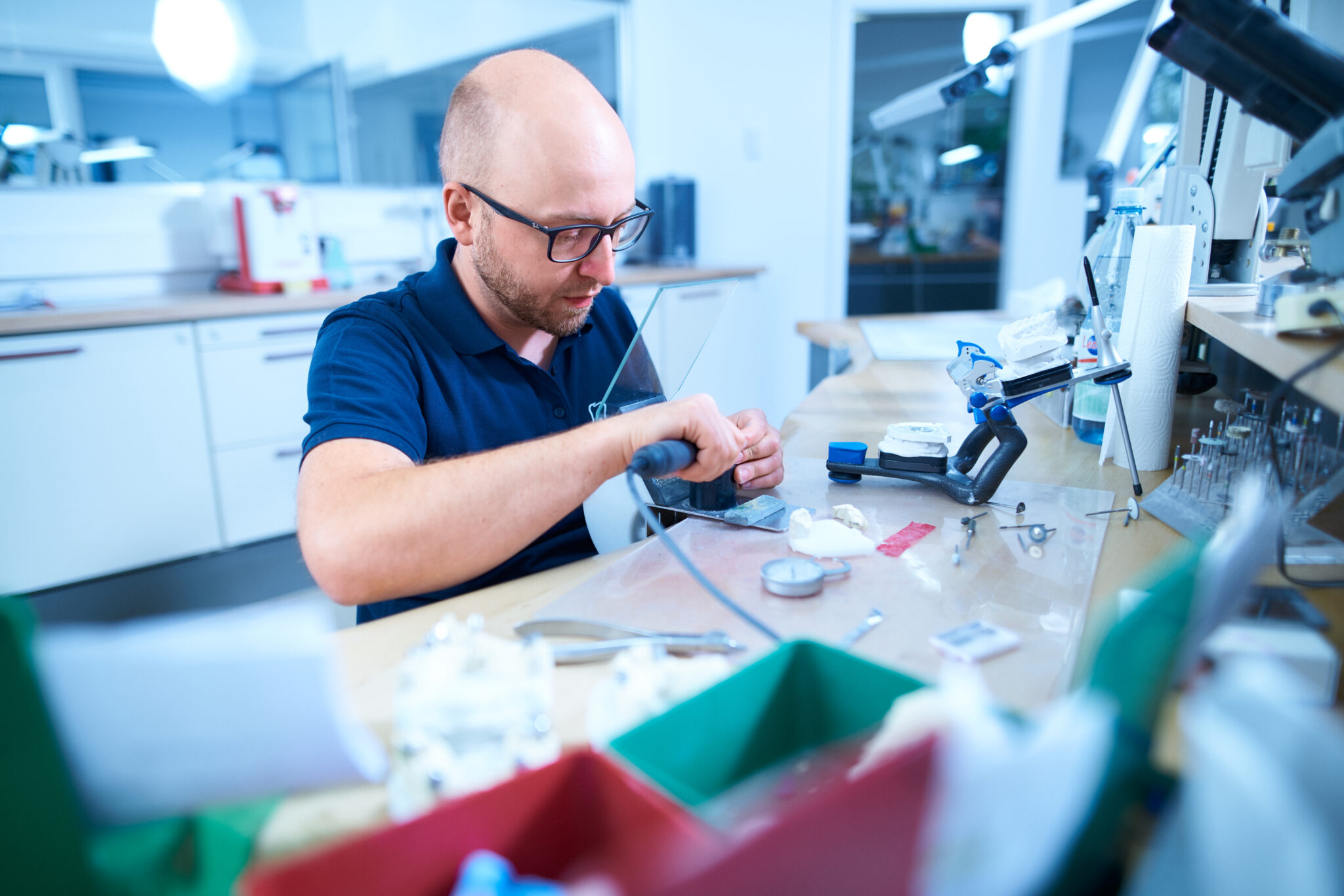 Zahntechniker von Dentatec bei der Bearbeitung von Zahnersatz am Laborarbeitsplatz