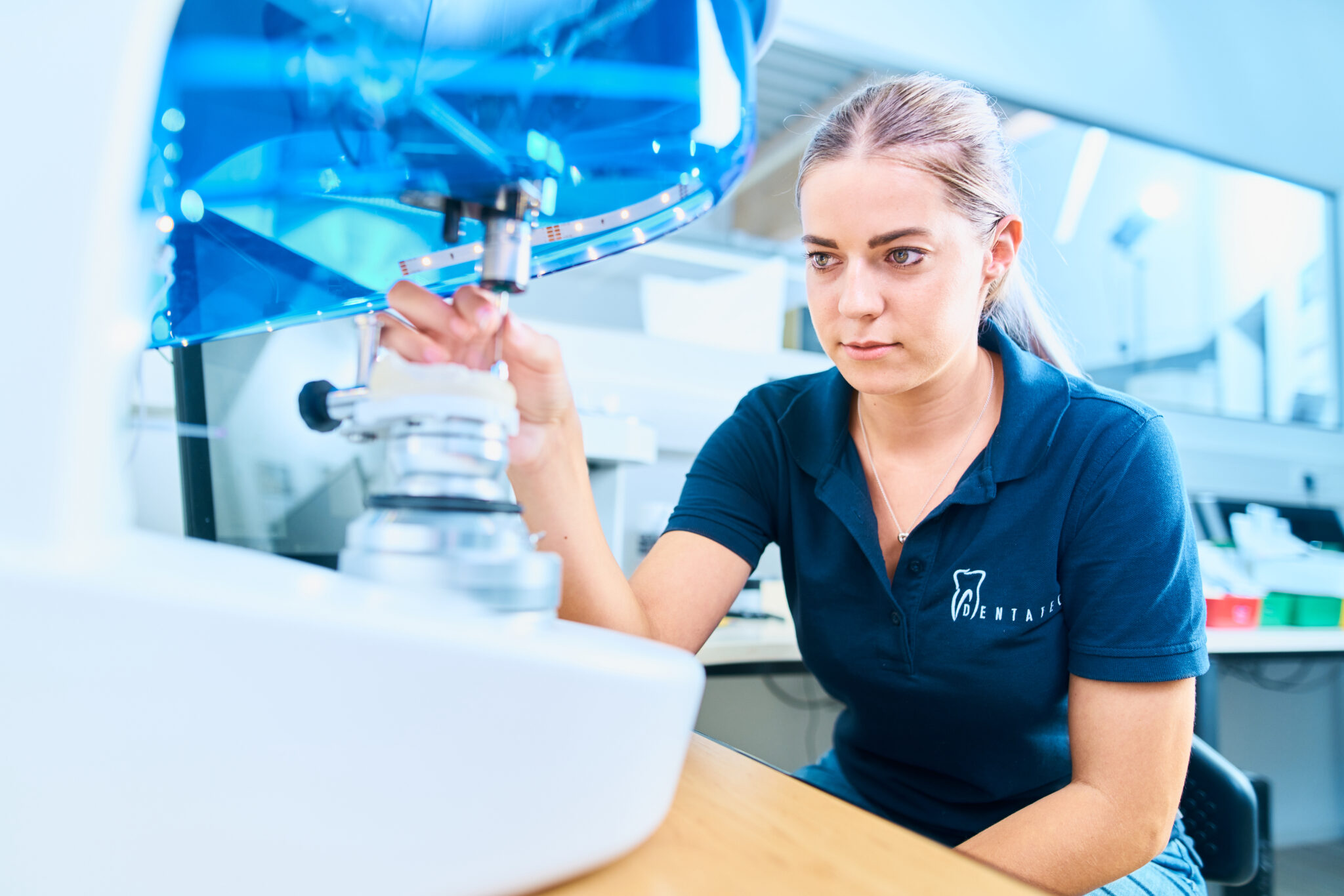 Zahntechnikerin von Dentatec bei der Arbeit an einem Dentalgerät im Labor