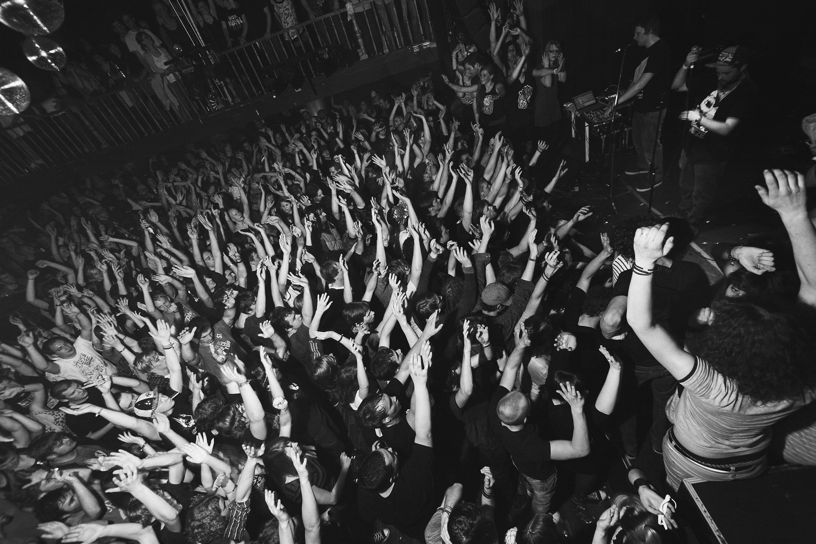 Publikum mit erhobenen Armen bei einem Konzert in Kreuzberg in Schwarzweiß