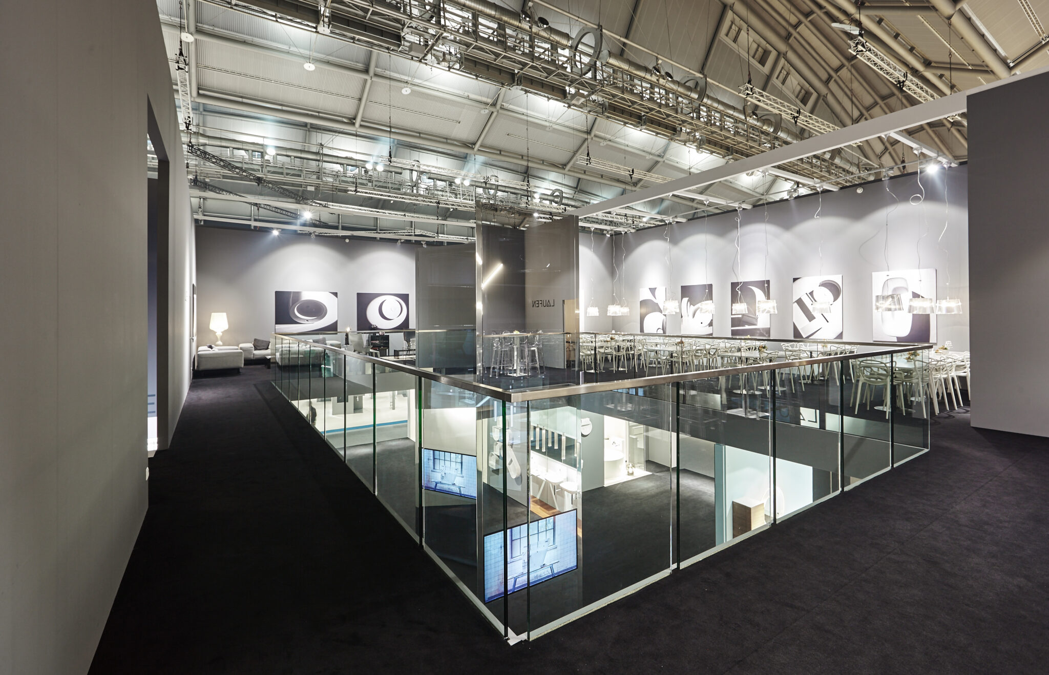 Blick über die Galerie des LAUFEN-Showrooms mit Glasbrüstungen, Produktgrafiken und Ausstellungsflächen