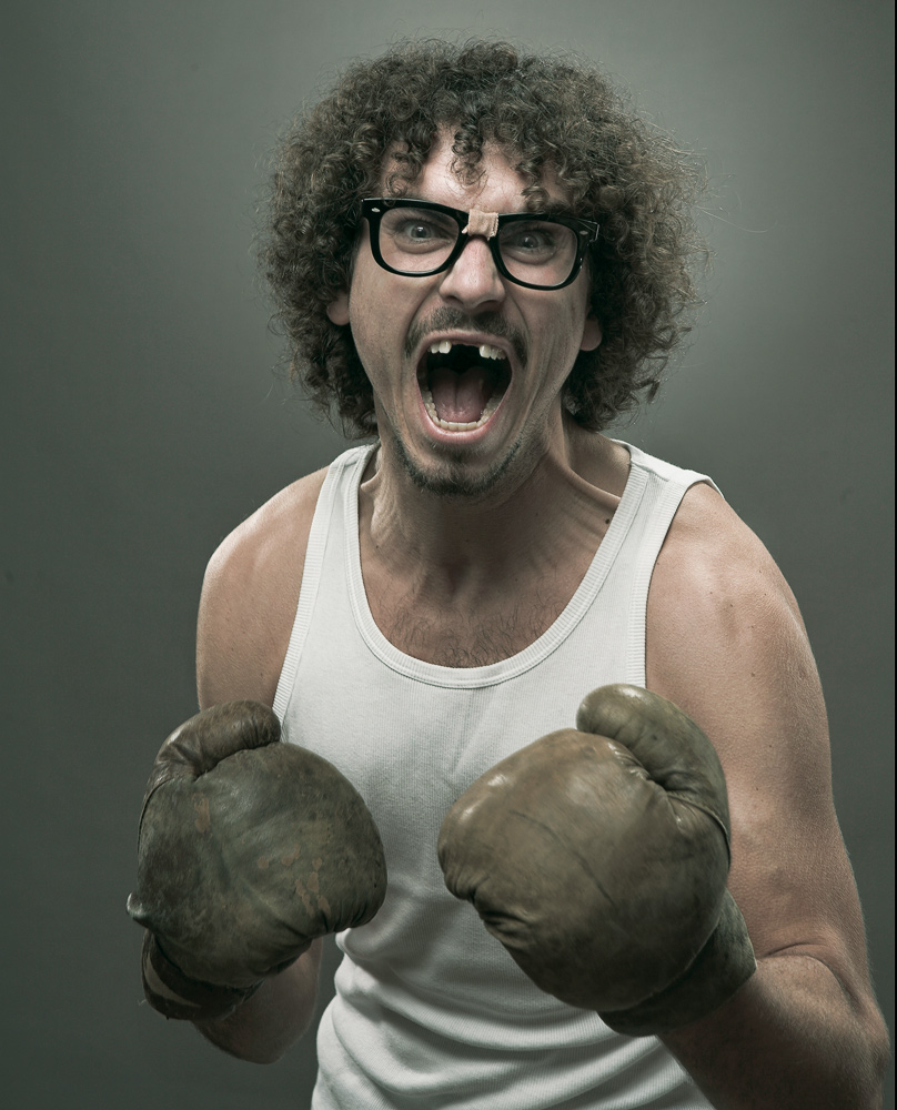Mann mit Brille und Boxhandschuhen in einem expressiven Studio-Portrait